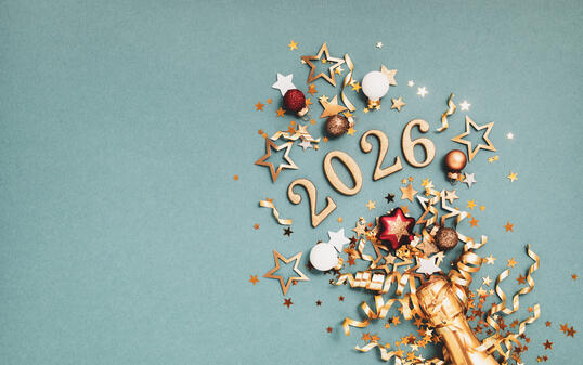 New Year festive background with golden champagne bottle, party streamers, Christmas balls, confetti stars and 2026 numbers top view.