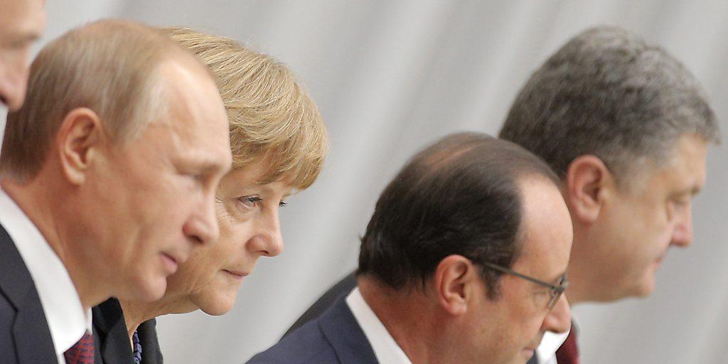 Steckten die Köpfe über den Ukraine-Konflikt zusammen: Putin, Merkel, Hollande und Poroschenko sprechen sich per Telefon ab. (Archivbild)