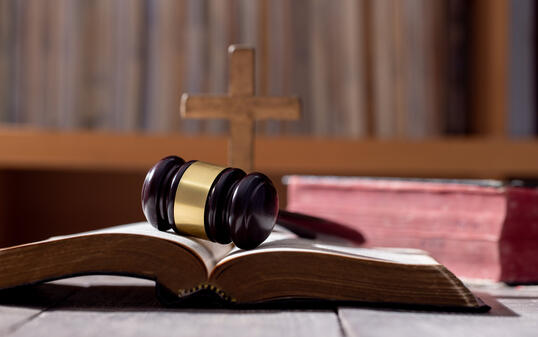 Holy bible book and judge's gavel on table background. Judicial system, constitution, democracy, rule of law. There are no people in the photo. There is free space to insert.