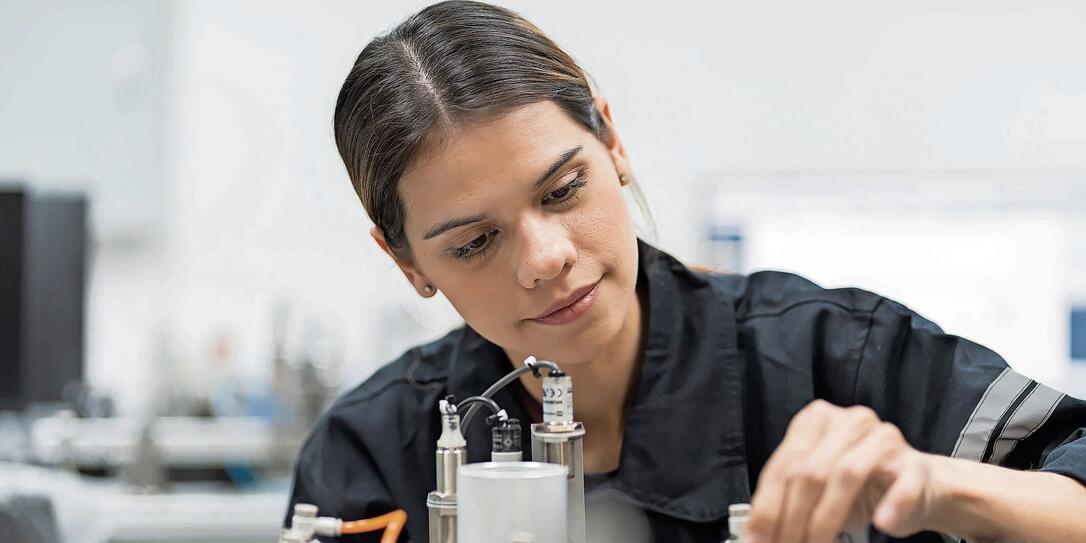 Female engineer training AI robot training kit and mechatronics engineering in the manufacturing automation and robotics academy room