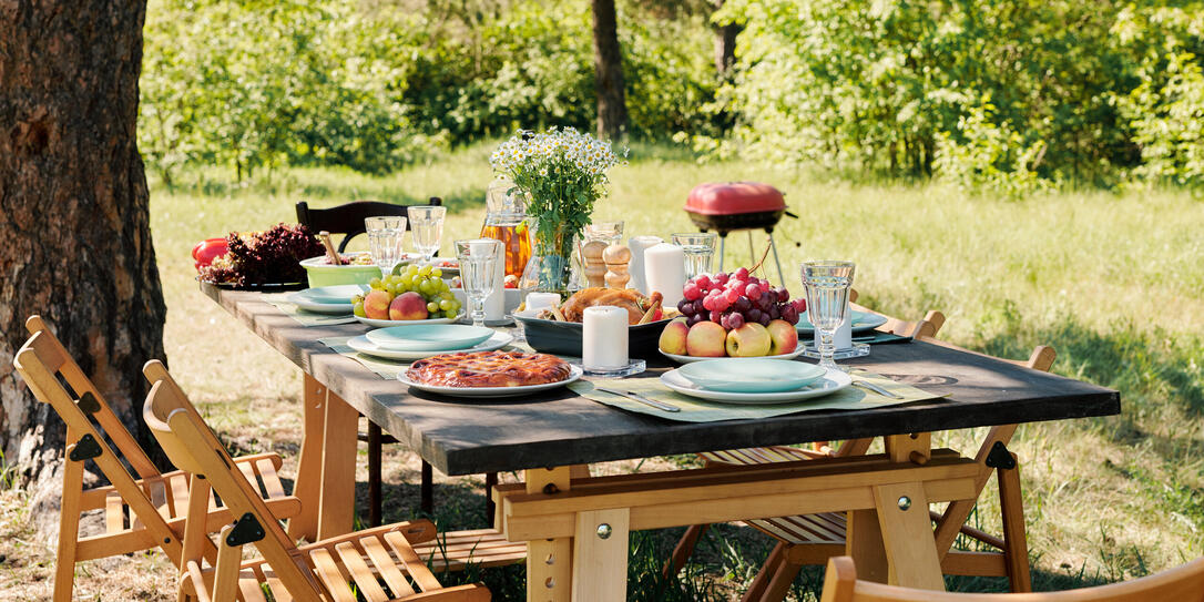 Group of chairs surrounding wooden served festive table with homemade food