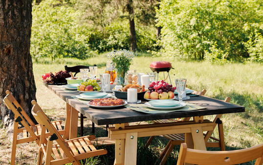Group of chairs surrounding wooden served festive table with homemade food