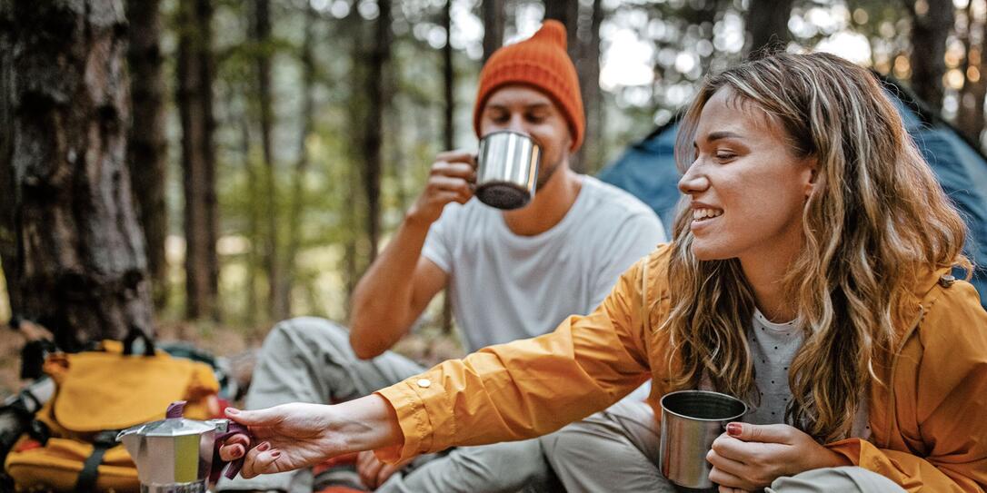 Young couple making coffee during hiking Young couple making coffee during hiking