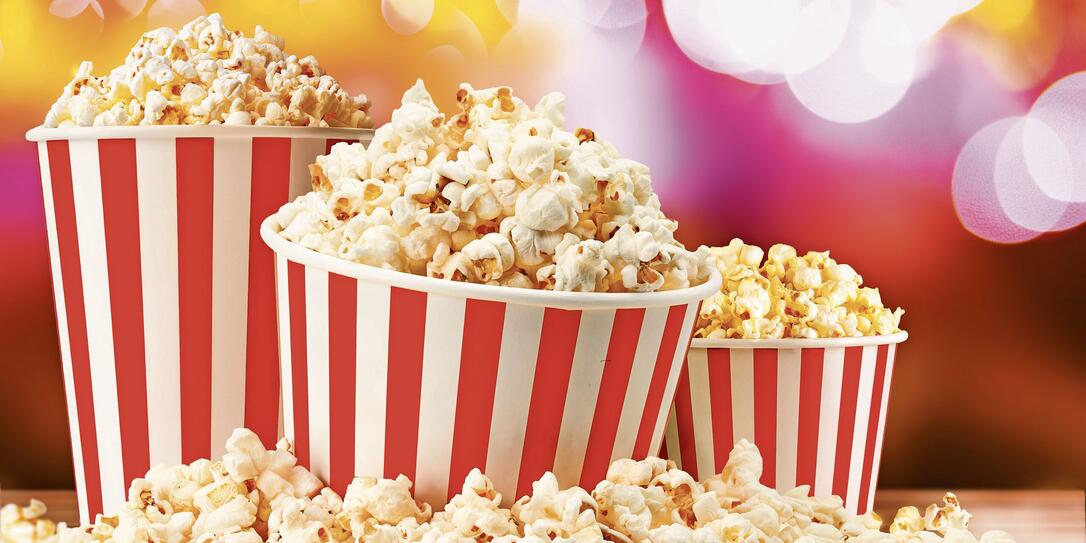 Popcorn in red and white striped paper buckets at the cinema. Popcorn stand