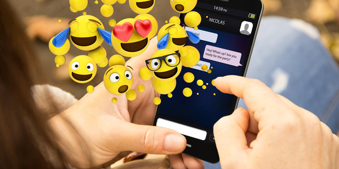 woman sending emoticons with the phone at the park woman sending emoticons with the phone at the park