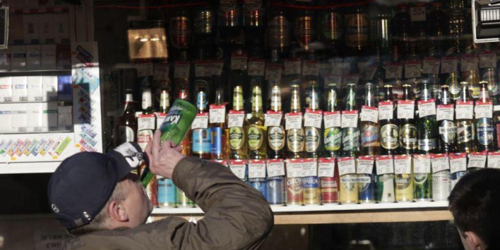 Ein Mann kippt seine Flasche bereits im Schnapsladen. (Archiv)