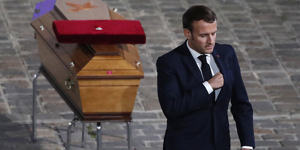 Der französische Staatspräsident Emmanuel Macron wendet sich bei der Gedenkveranstaltung  für Samuel Paty vom Sarg des ermordeten Lehrers ab. Foto: Francois Mori/AP/dpa