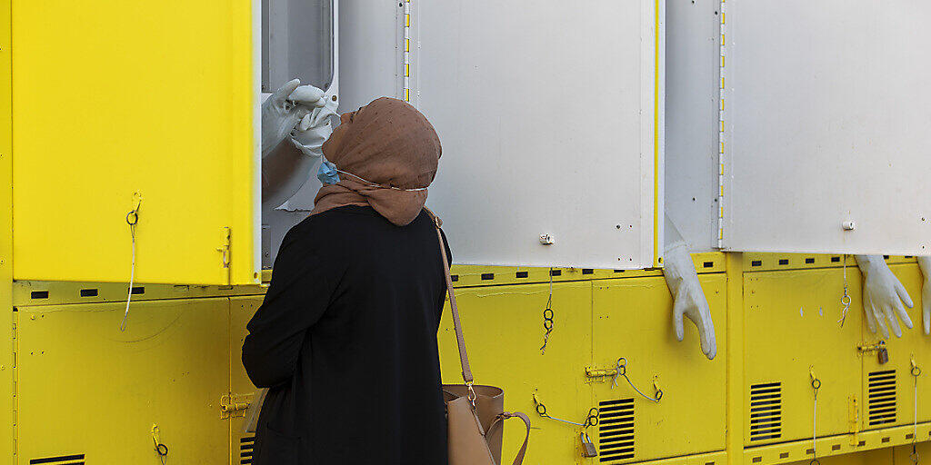 Eine Frau wird in einer mobilen Corona-Teststation in Ost-Jerusalem von einem Mitarbeiter des Gesundheitswesens auf das Virus getestet. Foto: Oded Balilty/AP/dpa