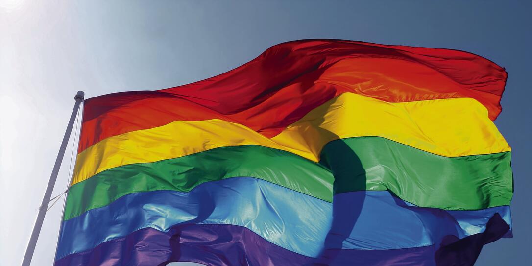 Rainbow flag, sun, wind, and blue sky