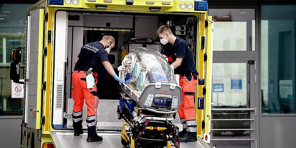 Sanitäter vom Bundeswehr Rettungsdienst bringen die Spezialtrage, mit der Nawalny in die Charite eingeliefert wurde, zurück in den Krankenwagen. Foto: Kay Nietfeld/dpa