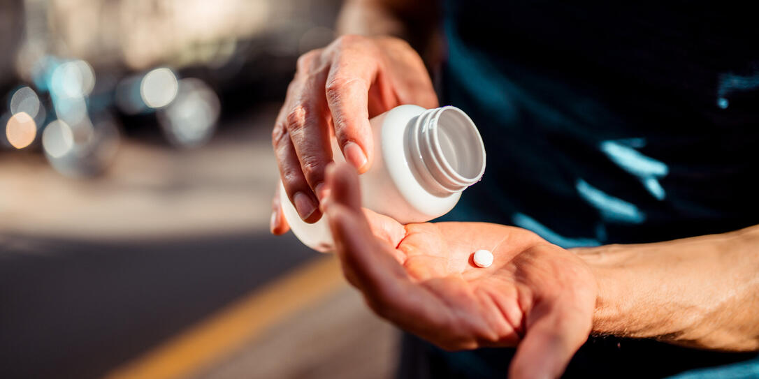 Close up of human hands. He is taking pill Close up of human hands. He is taking pill