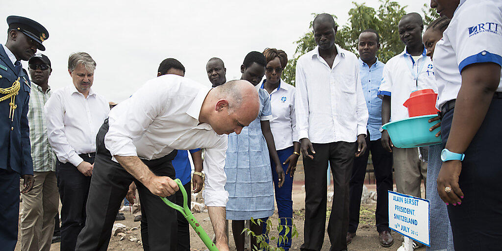 Bundespräsident Alain Berset pflanzt bei seinem Besuch im Flüchtlingslager Kakuma in Kenia einen Baum.