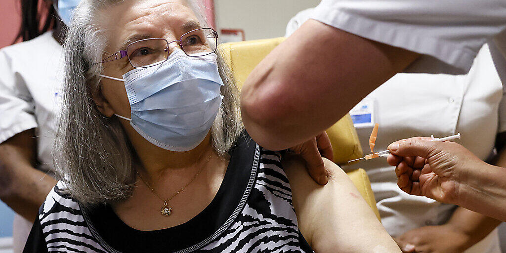 Die 78-jährige Mauricette wird im René-Muret Krankenhaus als erste Frau in Frankreich gegen Corona geimpft. Das stark von der Covid-19-Pandemie betroffene Frankreich hat seine Impfkampagne gegen das Coronavirus begonnen. Foto: Thomas Samson/AFP POOL/AP/dpa