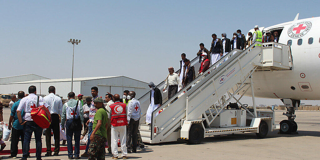 Jemenitische Gefangene, die von Huthis festgehalten wurden, verlassen nach ihrer Ankunft an einem Flughafen in Aden das Flugzeug. Der großangelegte zweitägige Austausch von Kriegsgefangenen zwischen den Konfliktparteien im Jemen ist erfolgreich beendet worden. Foto: Wail Shaif/dpa