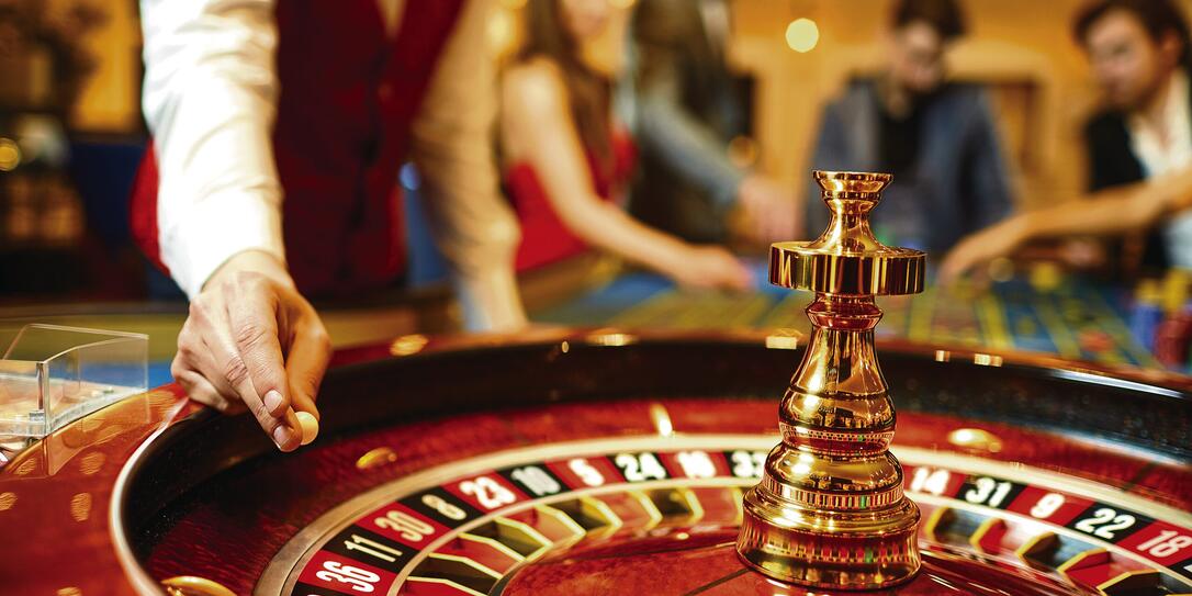 The croupier holds a roulette ball in a casino in his hand. The croupier holds a roulette ball in a casino in his hand.