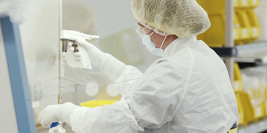 HANDOUT - Das Videostandbild zeigt eine Mitarbeiterin des US-Pharmakonzerns Moderna als sie an der Herstellung eines Corona-Impfstoffs arbeitet. Mit Moderna hat ein weiterer für Europa relevanter Hersteller vielversprechende Daten für seinen Impfstoff vorgelegt, der eine Wirksamkeit von 94,5 Prozent habe. Foto: Moderna/PA Media/dpa - ACHTUNG: Nur zur redaktionellen Verwendung und nur mit vollständiger Nennung des vorstehenden Credits