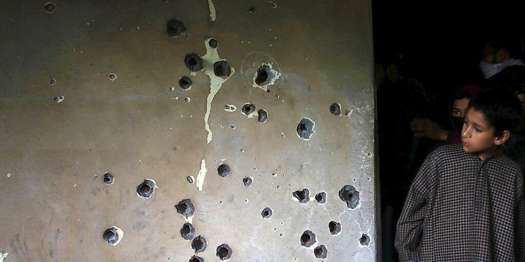 Ein Junge betrachtet die von Kugeln durchlöcherte Wand des Hauses im Süden Srinagars, in sich Zakir Musa verschanzt hatte. A