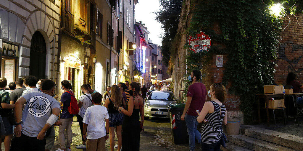 ARCHIV - Gäste stehen mit Mundschutzen vor einem Restaurant an. Italiens Regierung bereitet nach Medienberichten eine erneute Verschärfung der Anti-Corona-Maßnahmen vor, um den steilen Anstieg der Ansteckungszahlen zu bremsen. Foto: Cecilia Fabiano/LaPresse via ZUMA Press/dpa