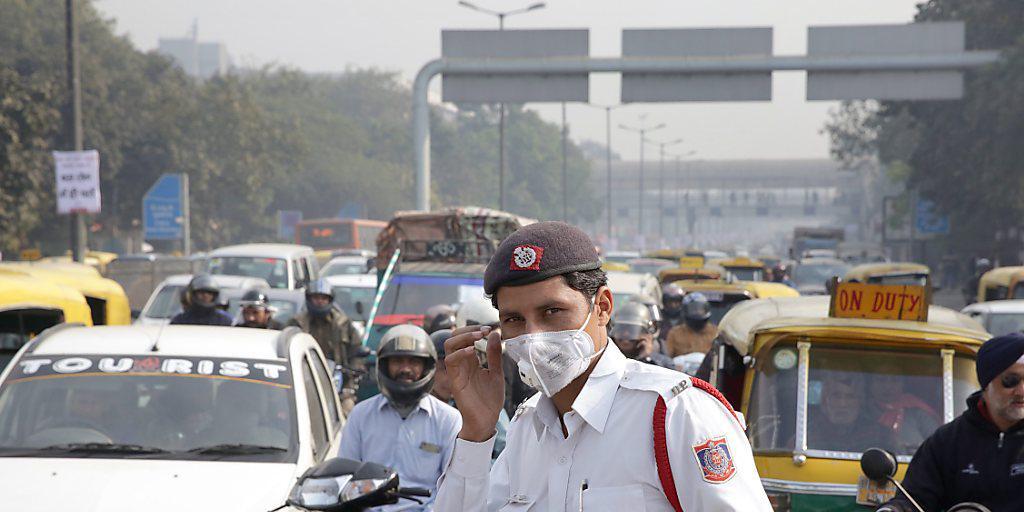 Ein Polizist in Indiens Hauptstadt Neu Delhi schützt sich mit einer Maske vor den Autoabgasen. Wegen des Smogs gilt ein Fahrverbot für Autos - abwechslungsweise für solche mit geraden und mit ungeraden Autonummern. Die Regel wird befolgt - was hier nicht auf den ersten Blick ersichtlich ist. Ein Polizist in Indiens Hauptstadt Neu Delhi schützt sich mit einer Maske vor den Autoabgasen. Wegen des Smogs gilt ein Fahrverbot für Autos - abwechslungsweise für solche mit geraden und mit ungeraden Autonummern. Die Regel wird befolgt - was hier nicht auf den ersten Blick ersichtlich ist.