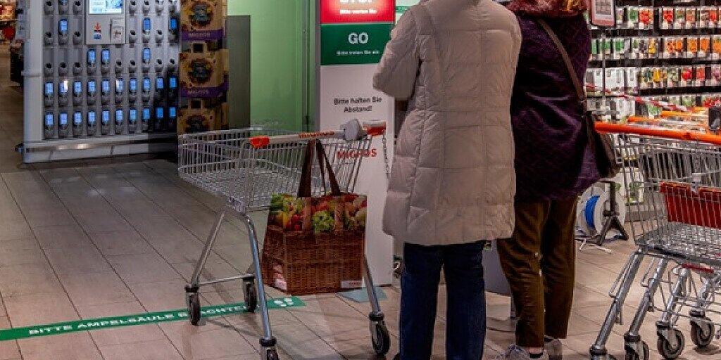 Eine Säule zeigt den Kunden mit "Stop" oder "Go" an, ob sie den Laden betreten dürfen, oder ob sich schon zu viele Menschen im Geschäft aufhalten. Eine Säule zeigt den Kunden mit "Stop" oder "Go" an, ob sie den Laden betreten dürfen, oder ob sich schon zu viele Menschen im Geschäft aufhalten.