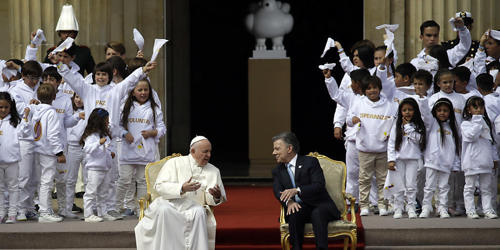 Papst Franziskus und Kolumbiens Präsident Juan Manuel Santos unterhalten sich vor einer Zeremonie.