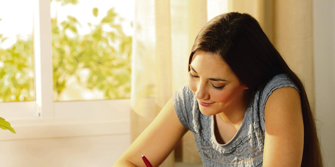 Girl writing a letter on a table