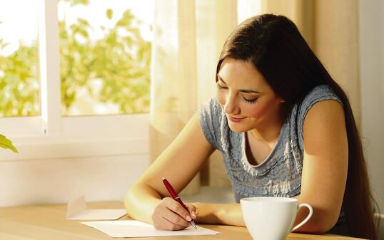 Girl writing a letter on a table