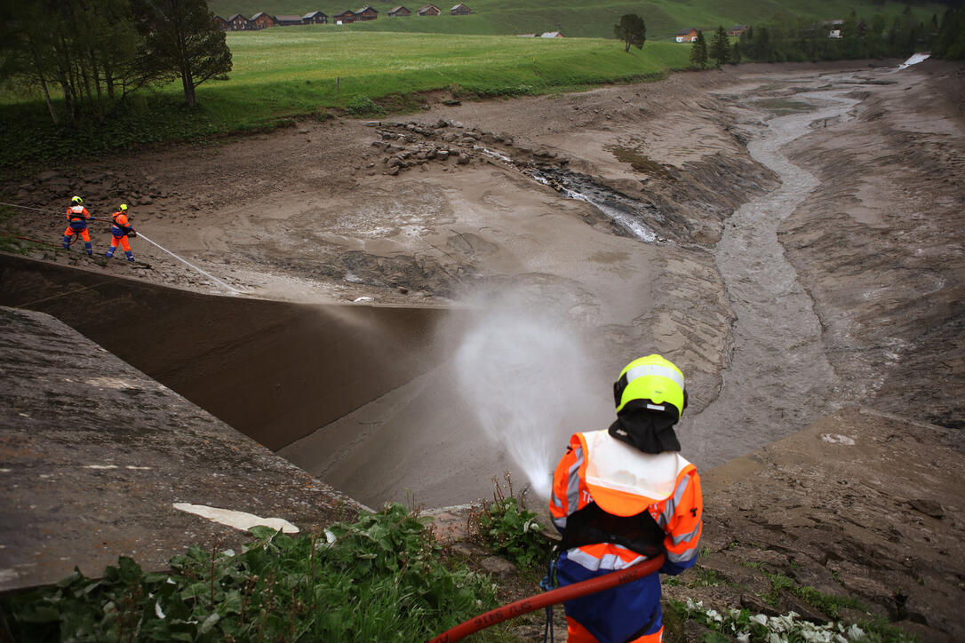 LKW und Feuerwehr reinigen den Stausee in Steg ,