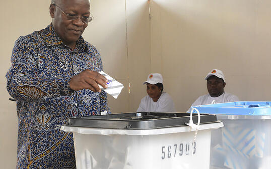 John Magufuli, amtierender Präsident von Tansania und Präsidentschaftskandidat bei der Präsidentenwahl, gibt in einem Wahllokal im ostafrikanischen Tansania seine Stimme ab. In einem angespannten Klima wählen die Bürger den Präsidenten und das Parlament neu. Der zunehmend autokratisch regierende Amtsinhaber Magufuli bewirbt sich um eine weitere fünfjährige Amtszeit. Oppositionsführer Lissu fordert ihn heraus - obwohl er erst vor drei Jahren einen Mordanschlag überlebte. Foto: Stringer/AP/dpa