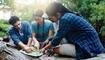 Map, nature and group of friends hiking in forest with route plan for adventure together. Travel, outdoor and people with paper guide for trekking in woods on weekend trip for discovery or journey.
