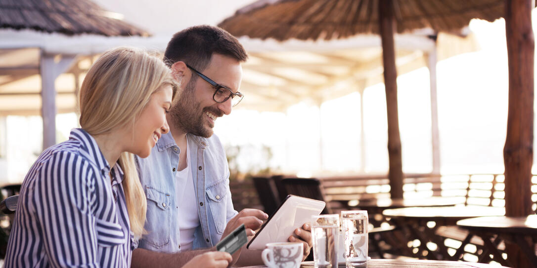 Bearded a handsome young man and his pretty blonde girl try to buy something on the online shop