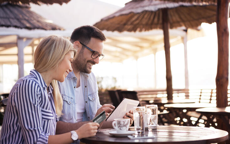 Bearded a handsome young man and his pretty blonde girl try to buy something on the online shop