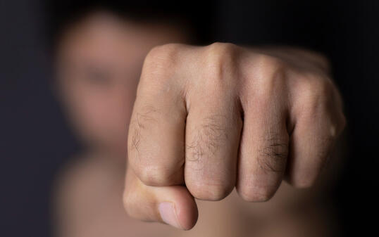 Violent man throwing punch with blurred face