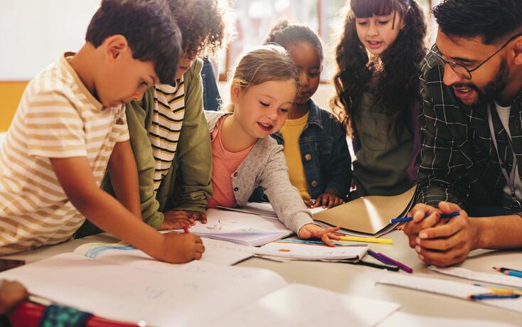Group of children doing an art project with their teacher