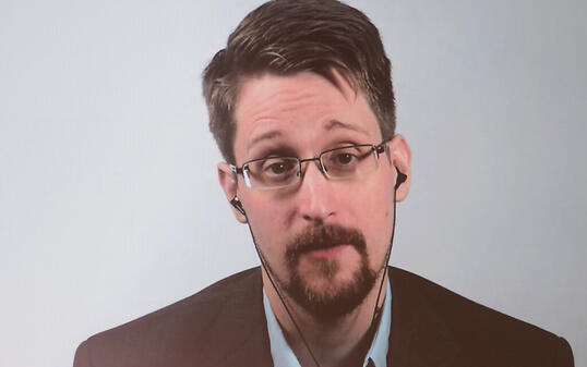 ARCHIV - Edward Snowden ist auf einer Video-Leinwand in der Urania zu sehen, während er bei einer Liveübertragung über sein Buch «Permanent Record: Meine Geschichte» spricht. Foto: Jörg Carstensen/dpa