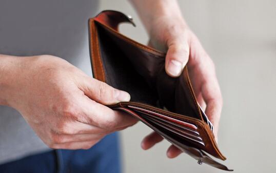 Empty wallet in the hands of an elderly man. Business concept.
