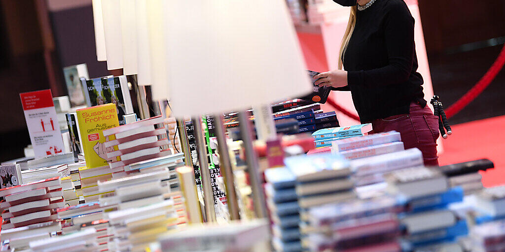 Eine Mitarbeiterin der Frankfurter Buchmesse steht vor der Eröffnungspressekonferenz der Frankfurter Buchmesse an einem Buchstand in der Festhalle. Foto: Arne Dedert/dpa pool/dpa