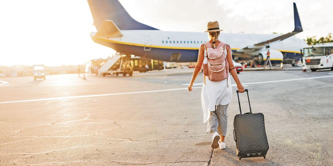 Back view of a woman walking towards the plane, ready to board and begin her vacation