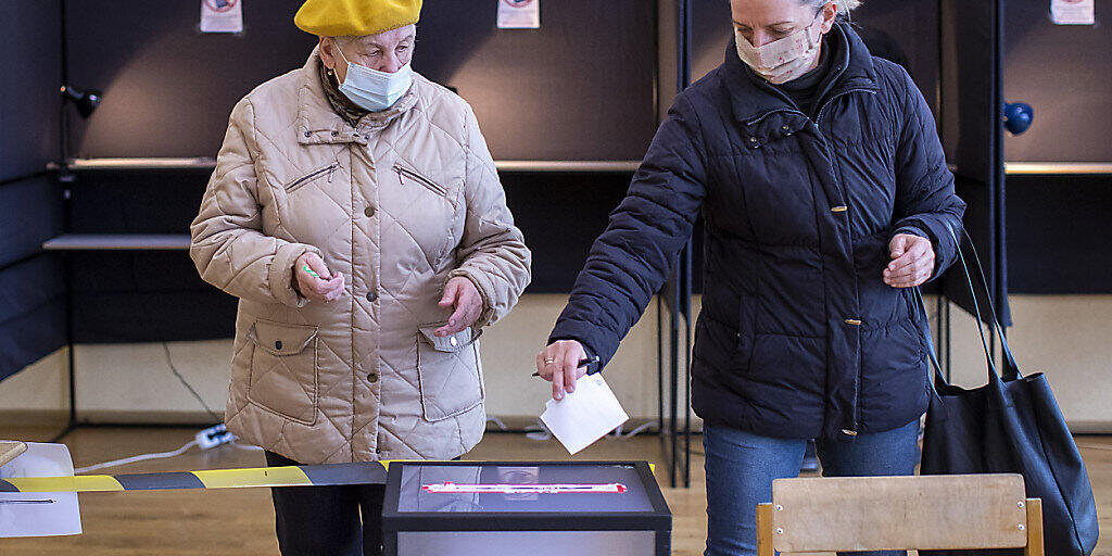 Zwei Frauen bei ihrer Stimmabgabe in einem Wahllokal in der litauischen Hauptstadt Vilnius. Foto: Mindaugas Kulbis/AP/dpa
