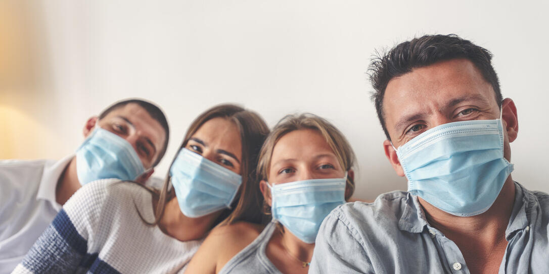 Family at home with surgical masks. They are brothers and sisters.