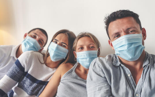 Family at home with surgical masks. They are brothers and sisters.