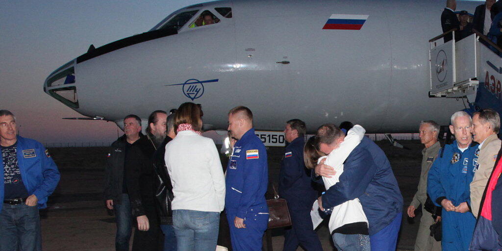 Wohlauf: US-Astronaut Nick Hague wird bei seiner Ankunft am Flughafen von Baikonur umarmt. In der Bildmitte sein russischer Kollege Alexej Owtschinin.