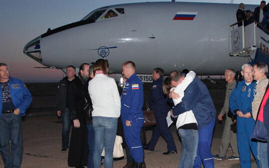 Wohlauf: US-Astronaut Nick Hague wird bei seiner Ankunft am Flughafen von Baikonur umarmt. In der Bildmitte sein russischer Kollege Alexej Owtschinin.