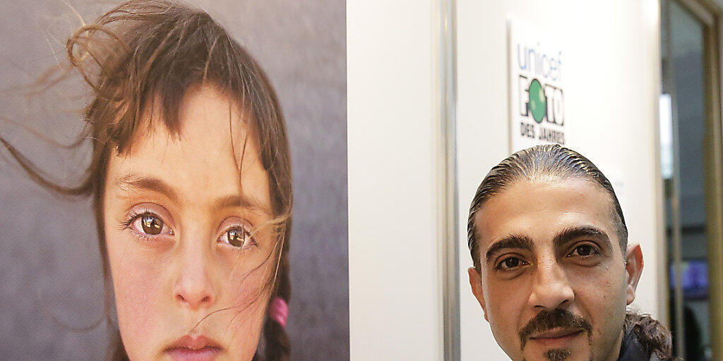 Fotograf Muhammend Muheisen neben seinem Bild, das zum Unicef-"Foto des Jahres" gekürt wurde.