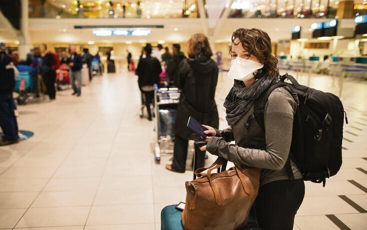 At the airport with a face mask