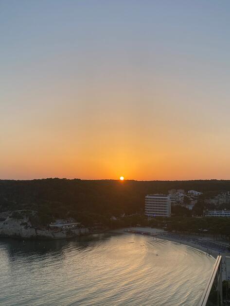 Magischer Sonnenuntergang durch köstliches Abendessen an der Küste