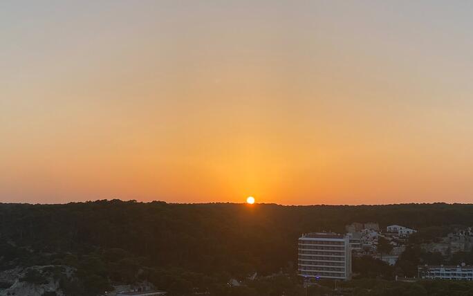 Magischer Sonnenuntergang durch köstliches Abendessen an der Küste