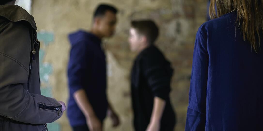 Teenage boys fighting, bullying and self-defense, violence, blurred background