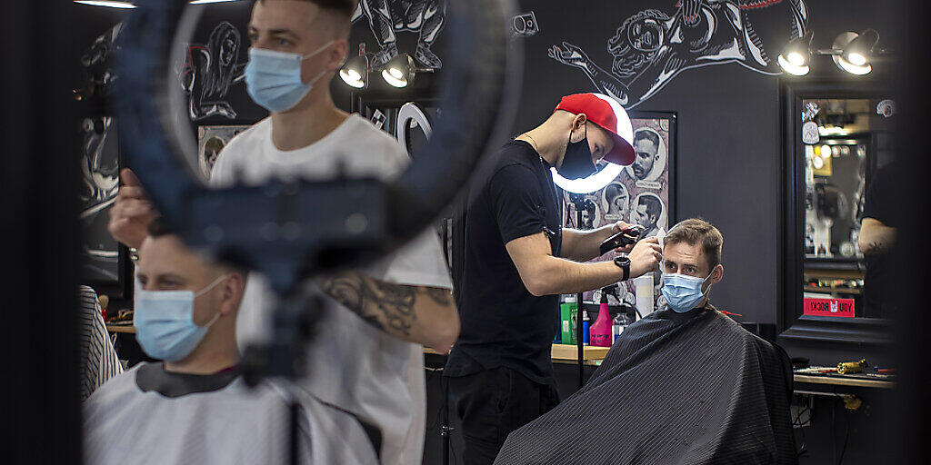Kunden lässt sich in einem Friseursalon in Vilnius die Haare schneiden - alle ragen einen Mund-Nasen-Schutz. Angesichts der rasant steigenden Corona-Infektionszahlen hat die litauische Regierung zuletzt 21 der 60 Kommunen des Landes unter lokale Quarantäne gestellt. Foto: Mindaugas Kulbis/AP/dpa Kunden lässt sich in einem Friseursalon in Vilnius die Haare schneiden - alle ragen einen Mund-Nasen-Schutz. Angesichts der rasant steigenden Corona-Infektionszahlen hat die litauische Regierung zuletzt 21 der 60 Kommunen des Landes unter lokale Quarantäne gestellt. Foto: Mindaugas Kulbis/AP/dpa