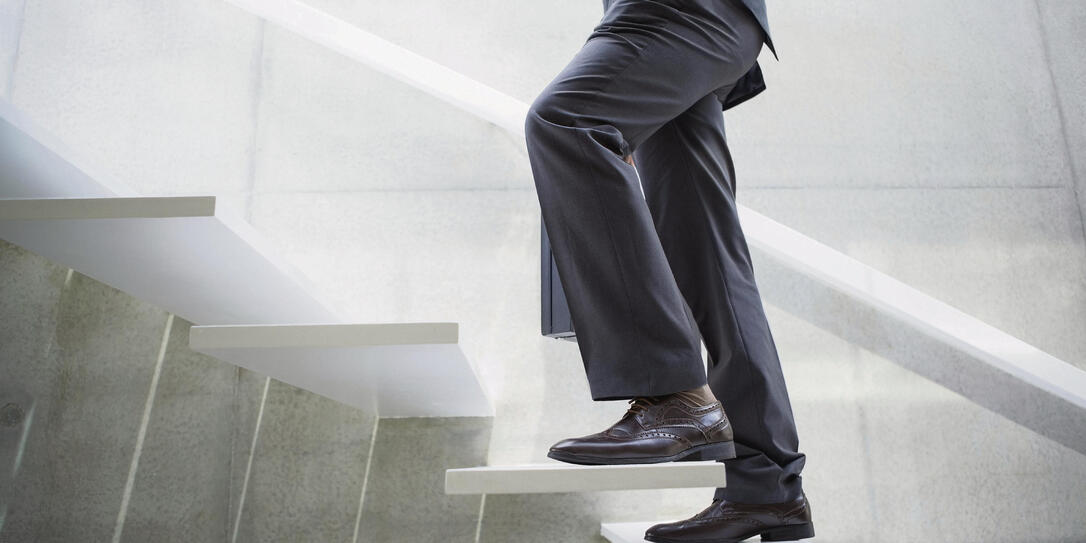 Businessman walking up the stairs in the hallway Businessman walking up the stairs in the hallway